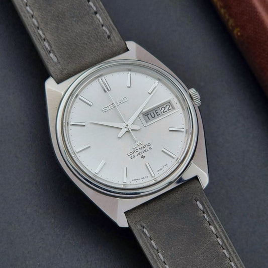 Vintage Seiko Wristwatch LordMatic 5606-7000 with gray leather strap on a dark background