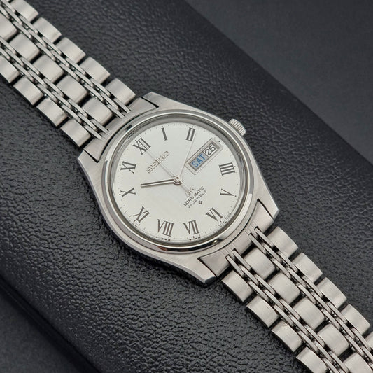 Vintage Seiko Wristwatch LordMatic 5606-7030 with a white dial on a dark textured background