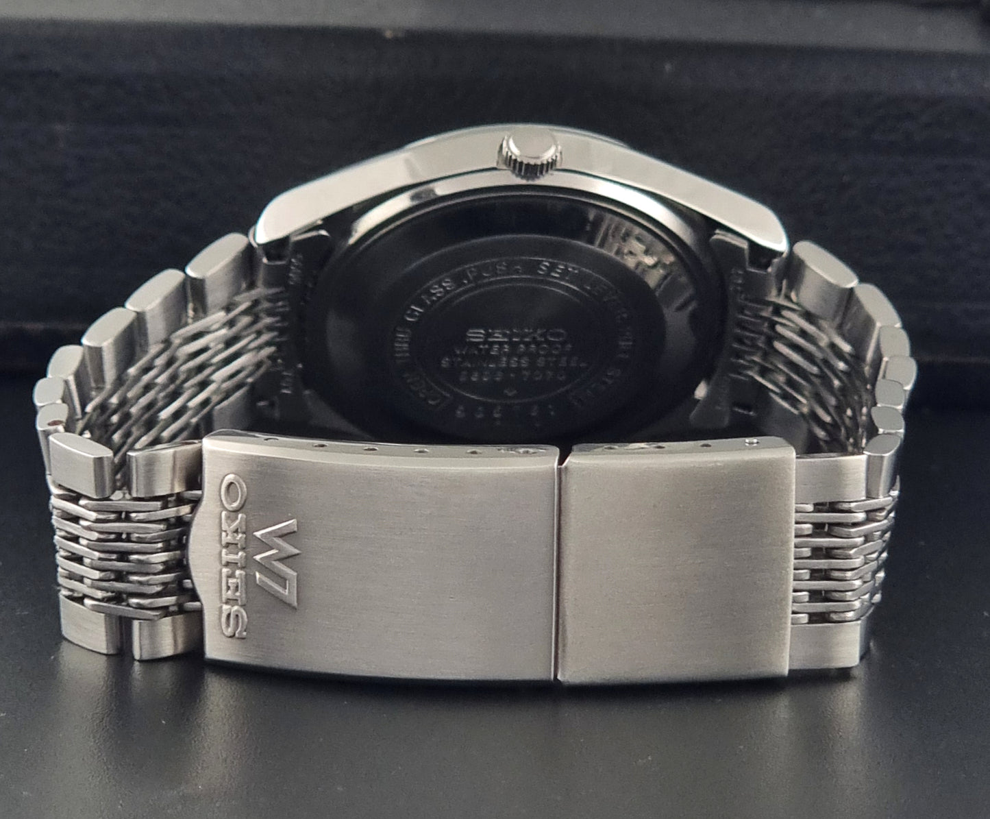 Vintage Seiko 5606-7070 watch LordMatic with a white face on a dark gray background clasp view