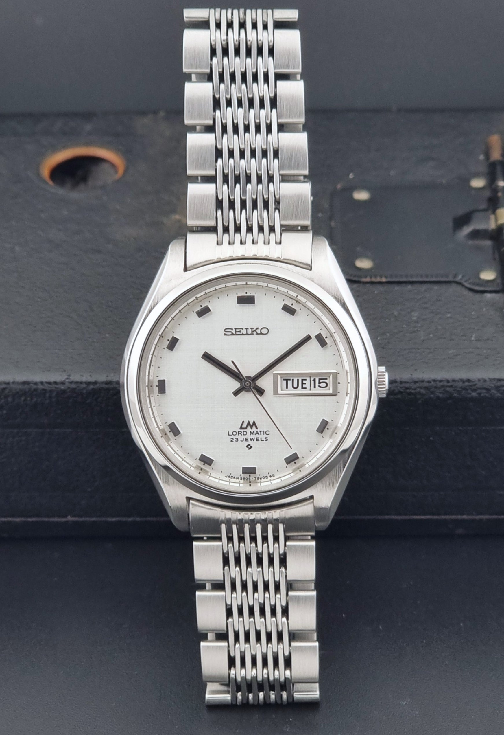 Vintage Seiko 5606-7070 watch LordMatic with a white face on a dark gray background dial view