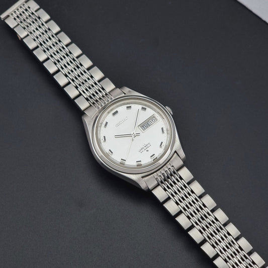Vintage Seiko 5606-7070 watch LordMatic with a white face on a dark gray background dial