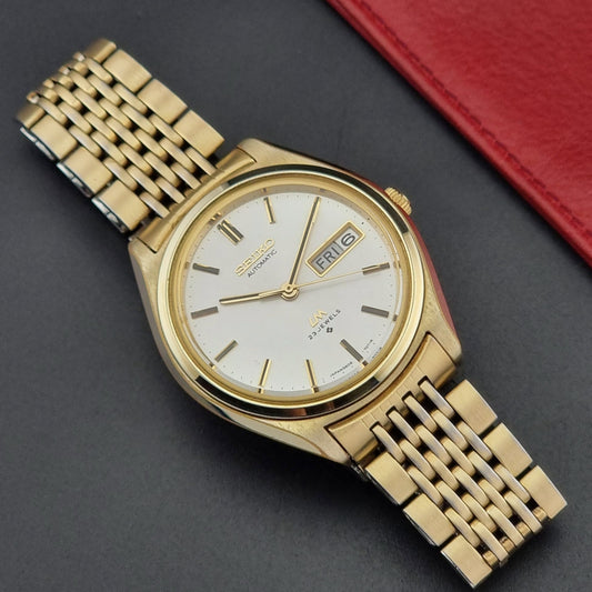 Vintage Seiko LordMatic 5606-7070 Gold wristwatch with a white face on a dark surface dial