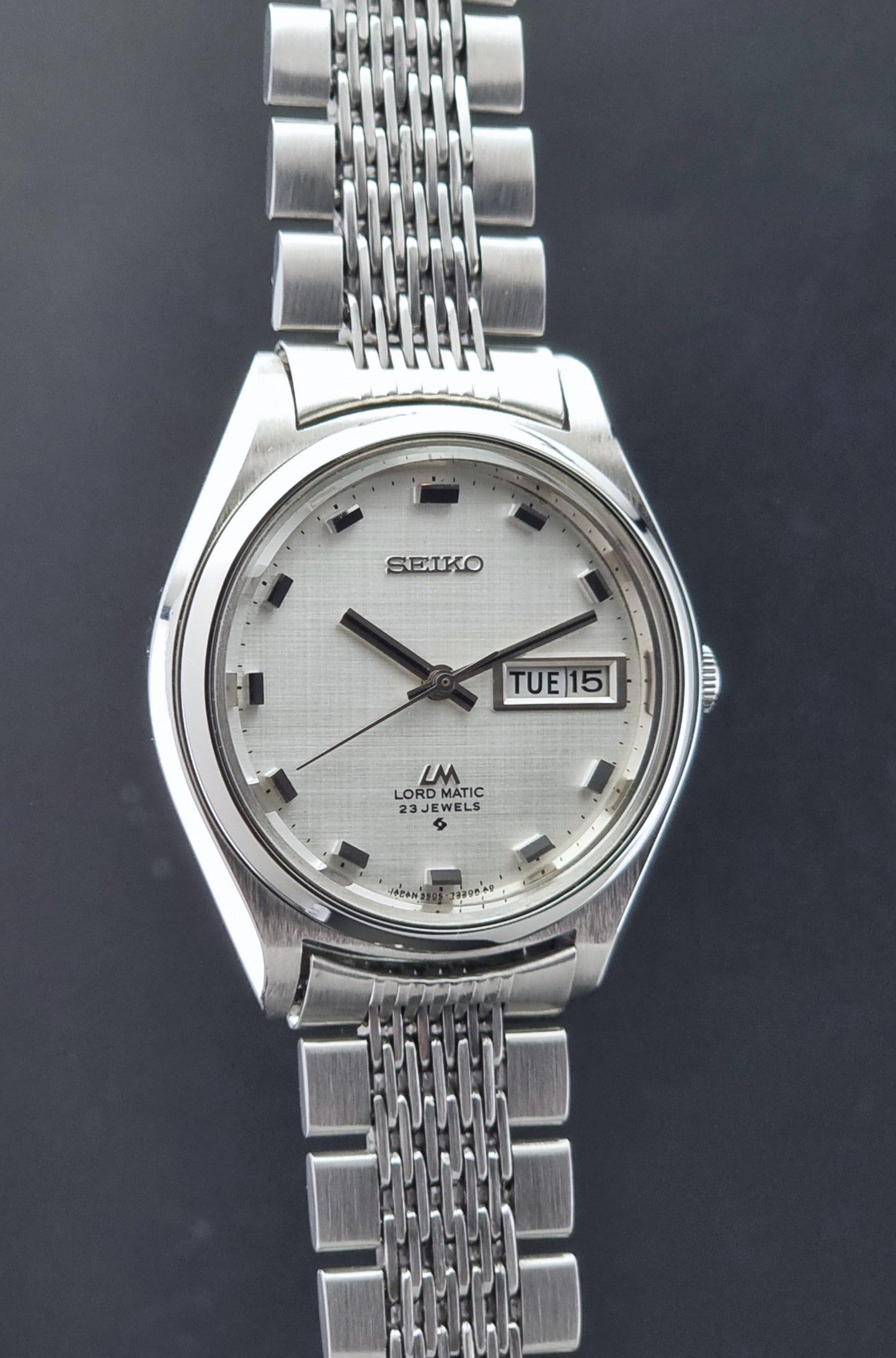 Vintage Seiko 5606-7070 watch LordMatic with a white face on a dark gray background side profile view