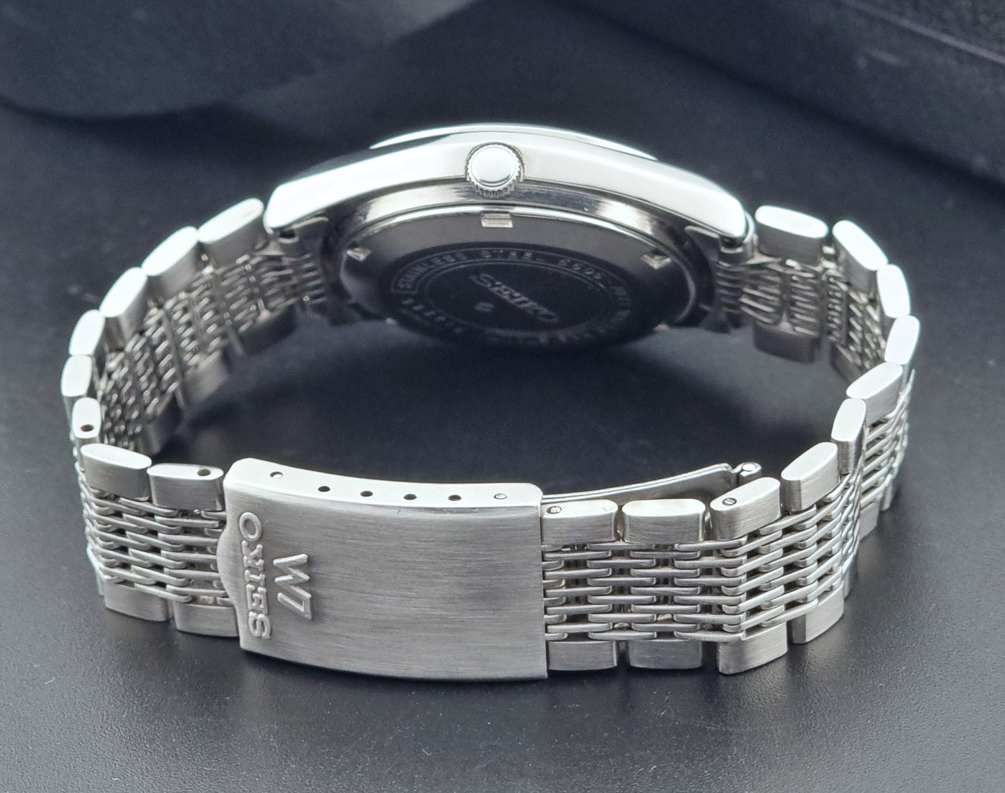 Vintage Seiko Wristwatch 5606-7071  with a metallic band on a dark background clasp view