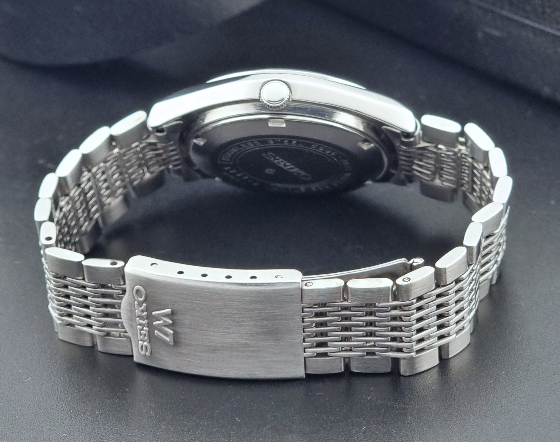 Vintage Seiko Wristwatch 5606-7071  with a metallic band on a dark background clasp view