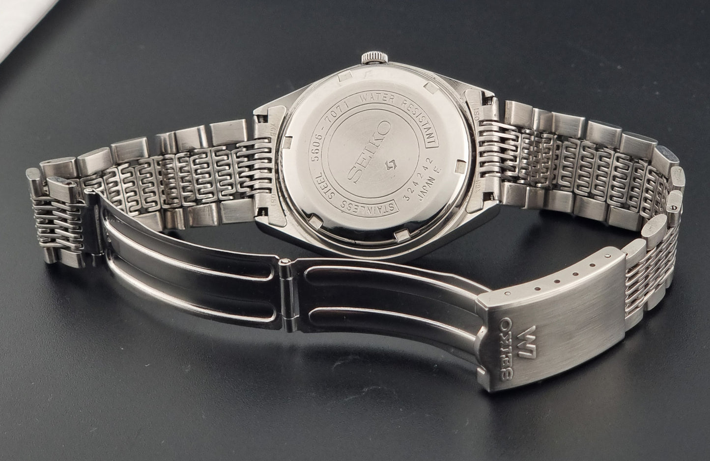 Vintage Seiko 5606-7071 watch LordMatic with a metallic band on a dark gray background clasp view