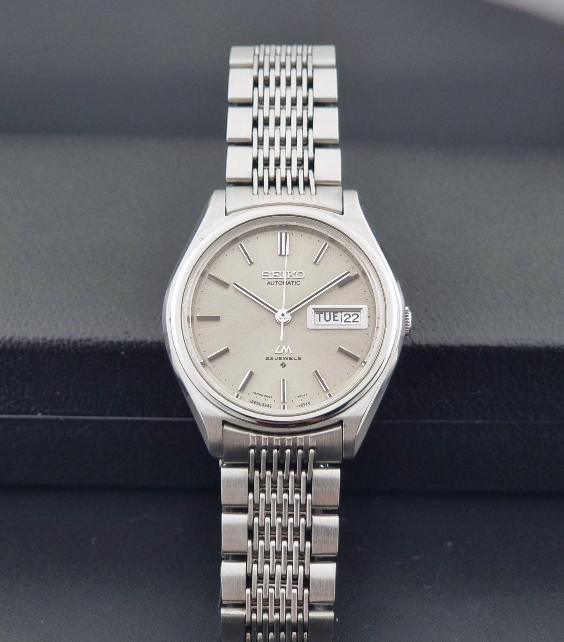 Vintage Seiko 5606-7071 watch LordMatic with a metallic band on a dark gray background dial view
