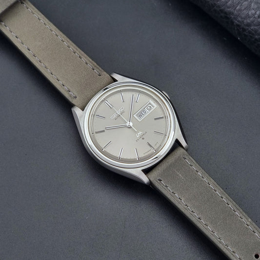 Vintage Seiko Wristwatch 5606-7071  with a grey strap on a dark background dial 