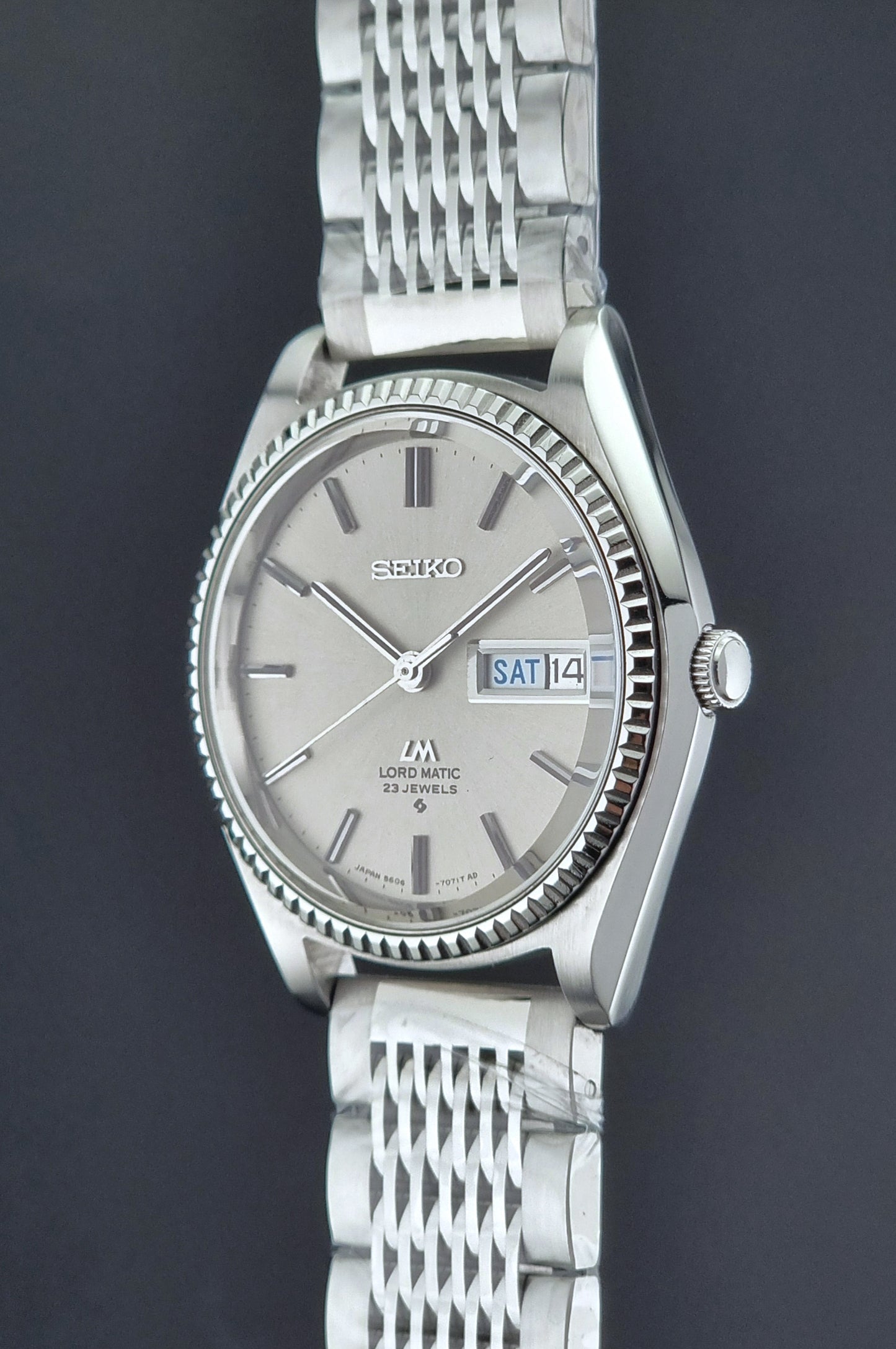 Seiko Wristwatch LordMatic 5606-7080  on a dark textured surface crown side profile