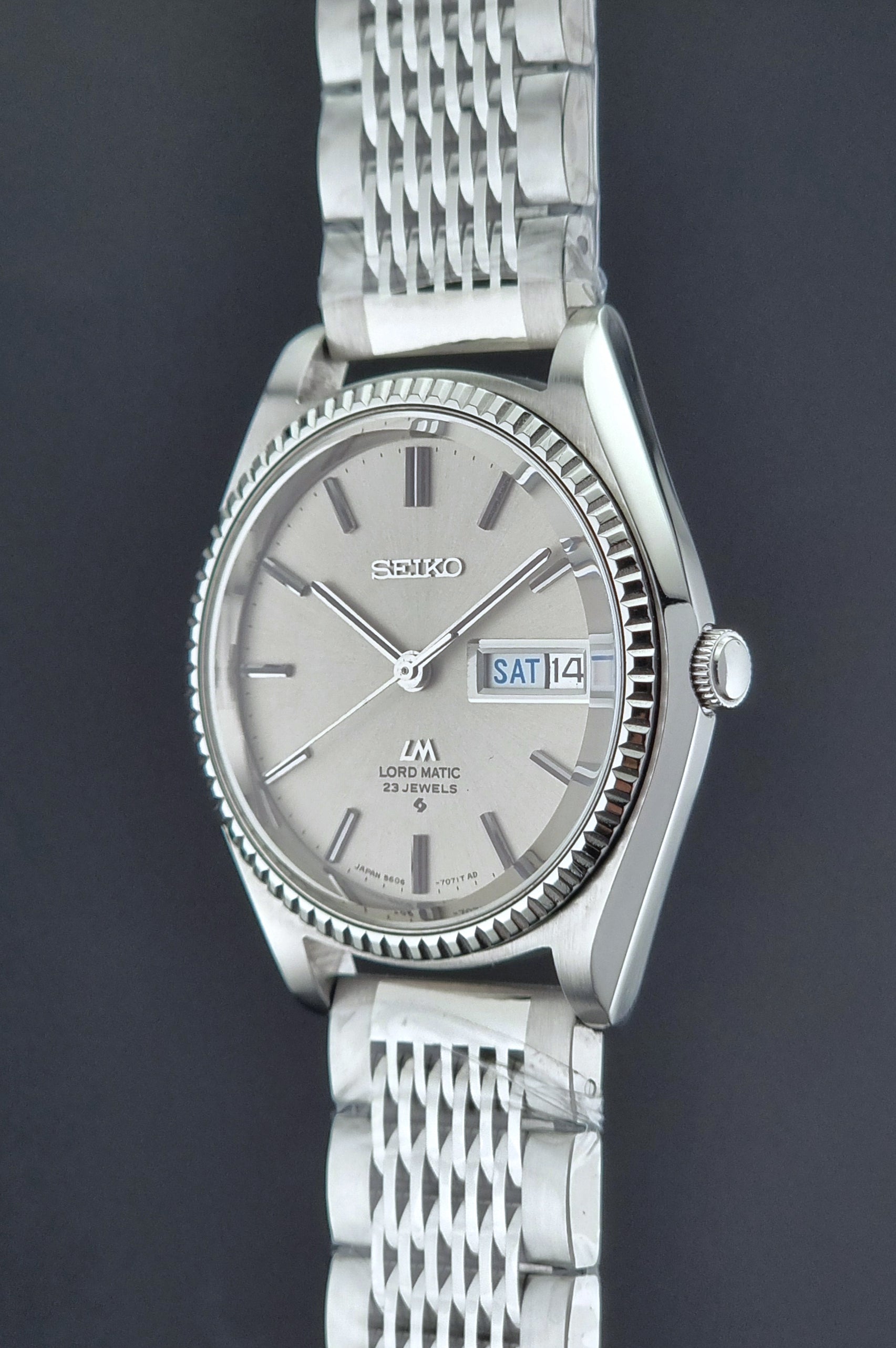 Seiko Wristwatch LordMatic 5606-7080  on a dark textured surface crown side profile