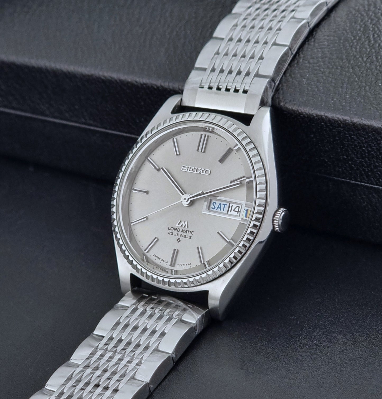 Seiko Wristwatch LordMatic 5606-7080  on a dark textured surface crown view