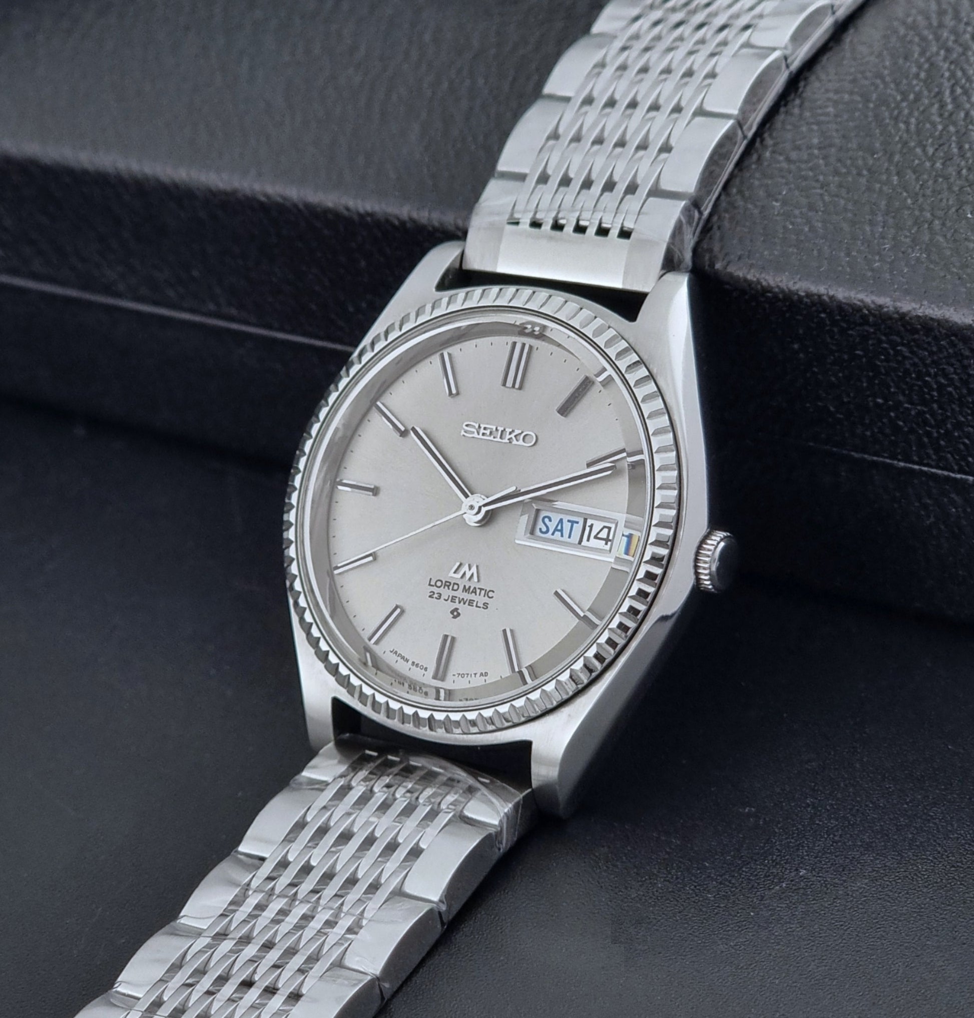 Seiko Wristwatch LordMatic 5606-7080  on a dark textured surface crown view