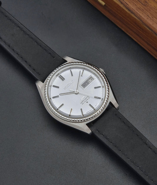 Vintage Seiko Wristwatch 5606-7080 LordMatic with black leather strap on a dark surface dial 