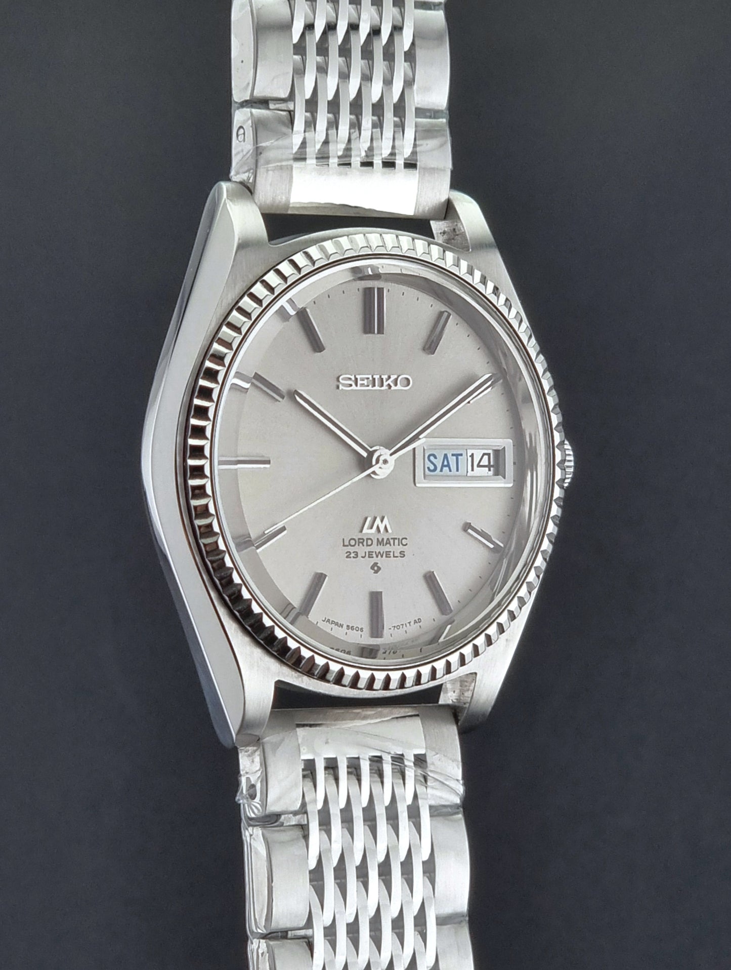 Seiko Wristwatch LordMatic 5606-7080  on a dark textured surface side profile