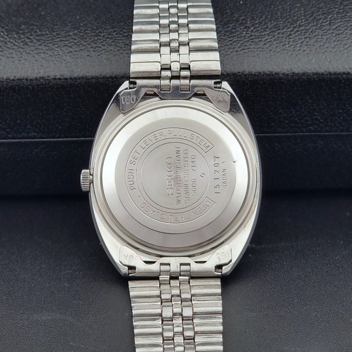 Seiko Wristwatch LordMatic 5606-7140 Vintage watch with a black face on a dark background case back view