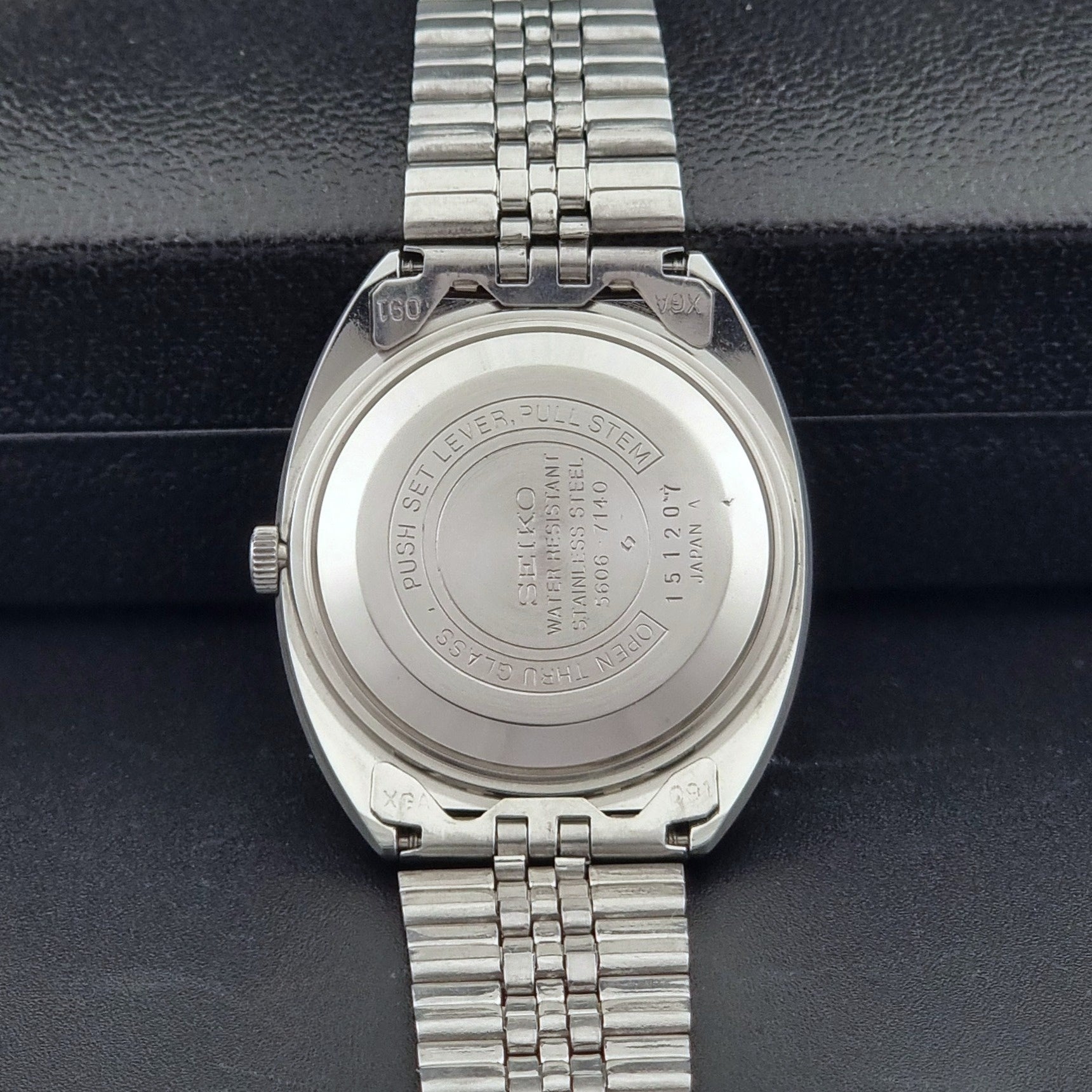 Seiko Wristwatch LordMatic 5606-7140 Vintage watch with a black face on a dark background case back view