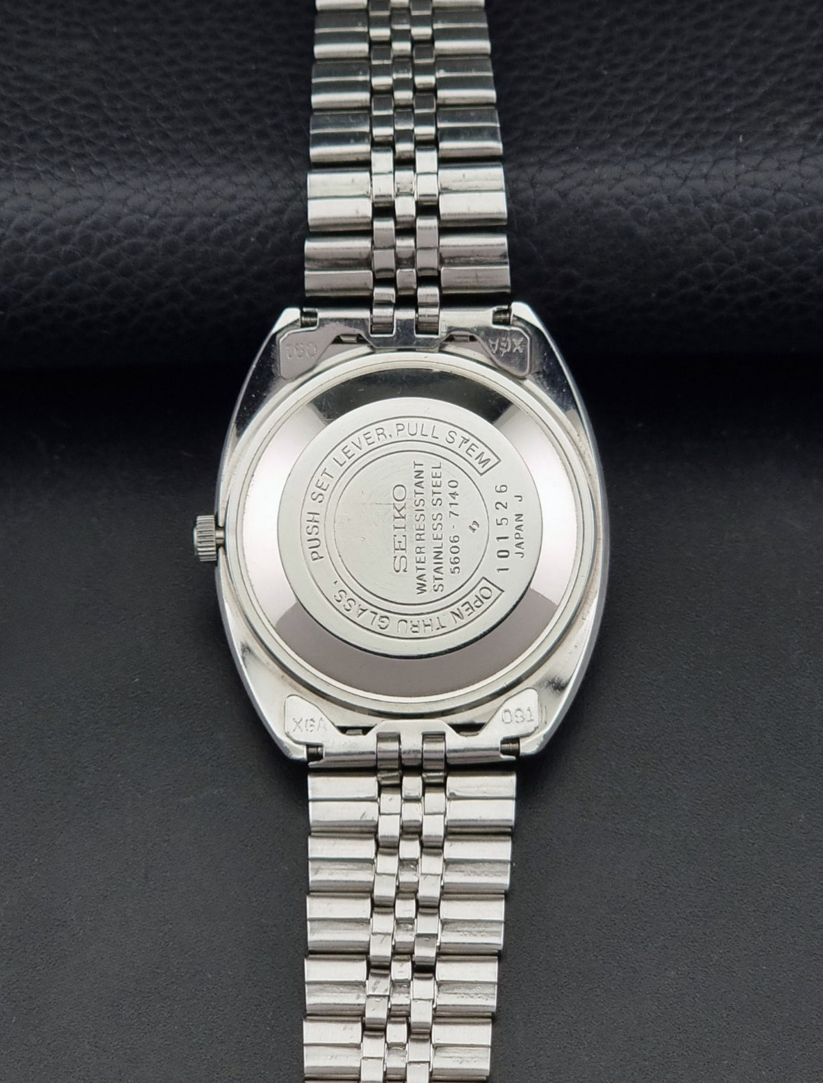 Vintage Seiko Wristwatch LordMatic 5606-7140 with  stainless steel bracelet on a dark background back view