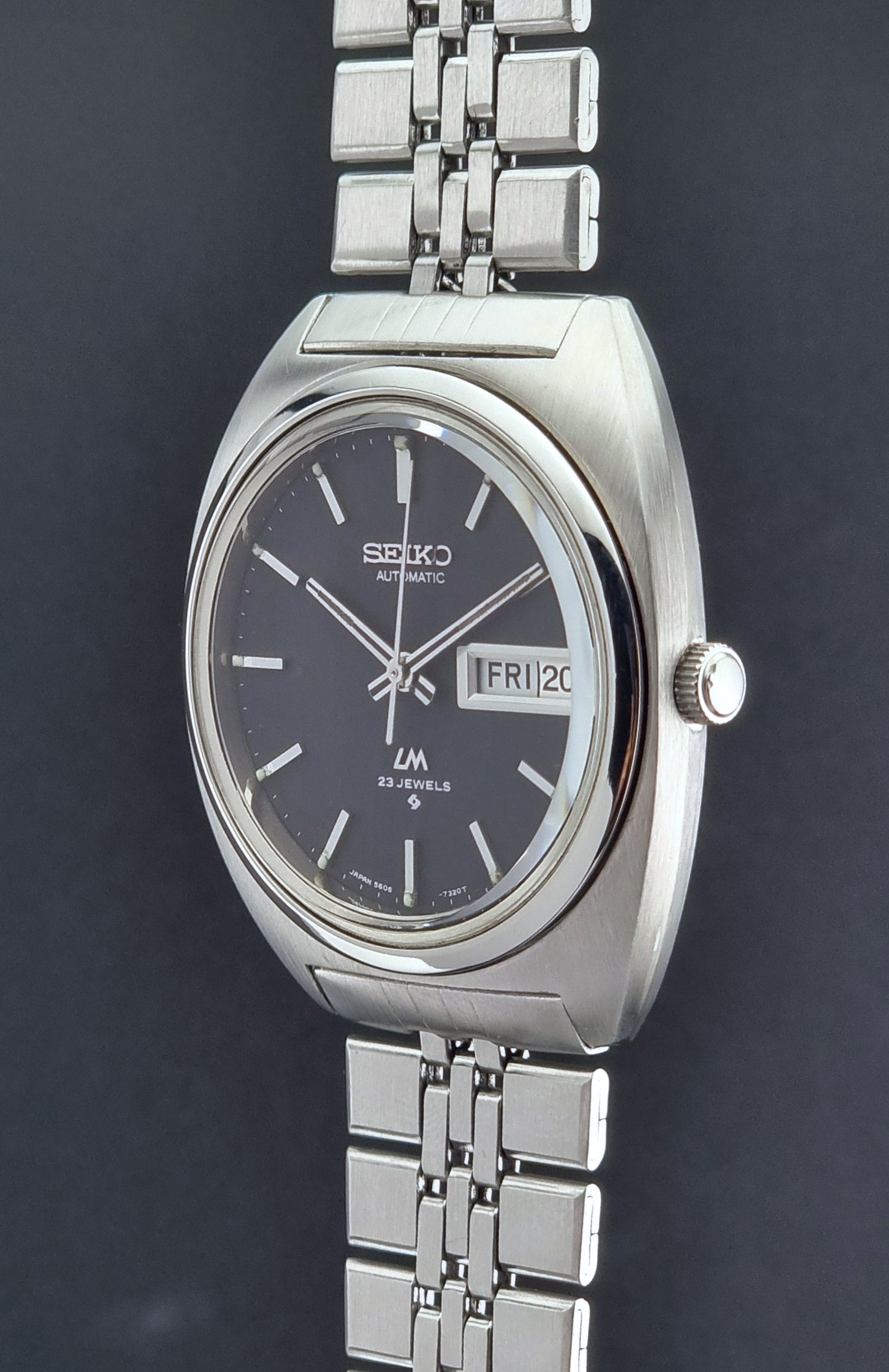 Vintage Seiko Lordmatic 5606-7140 watch with a dark face on a black background