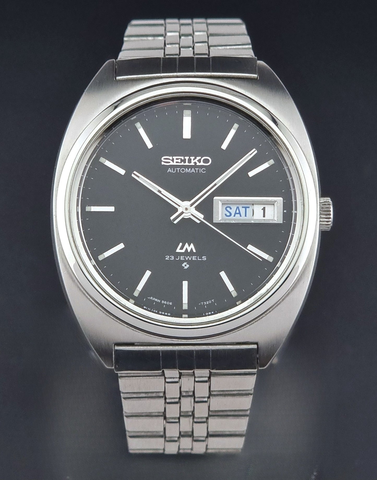 Seiko Wristwatch LordMatic 5606-7140 Vintage watch with a black face on a dark background close dial view