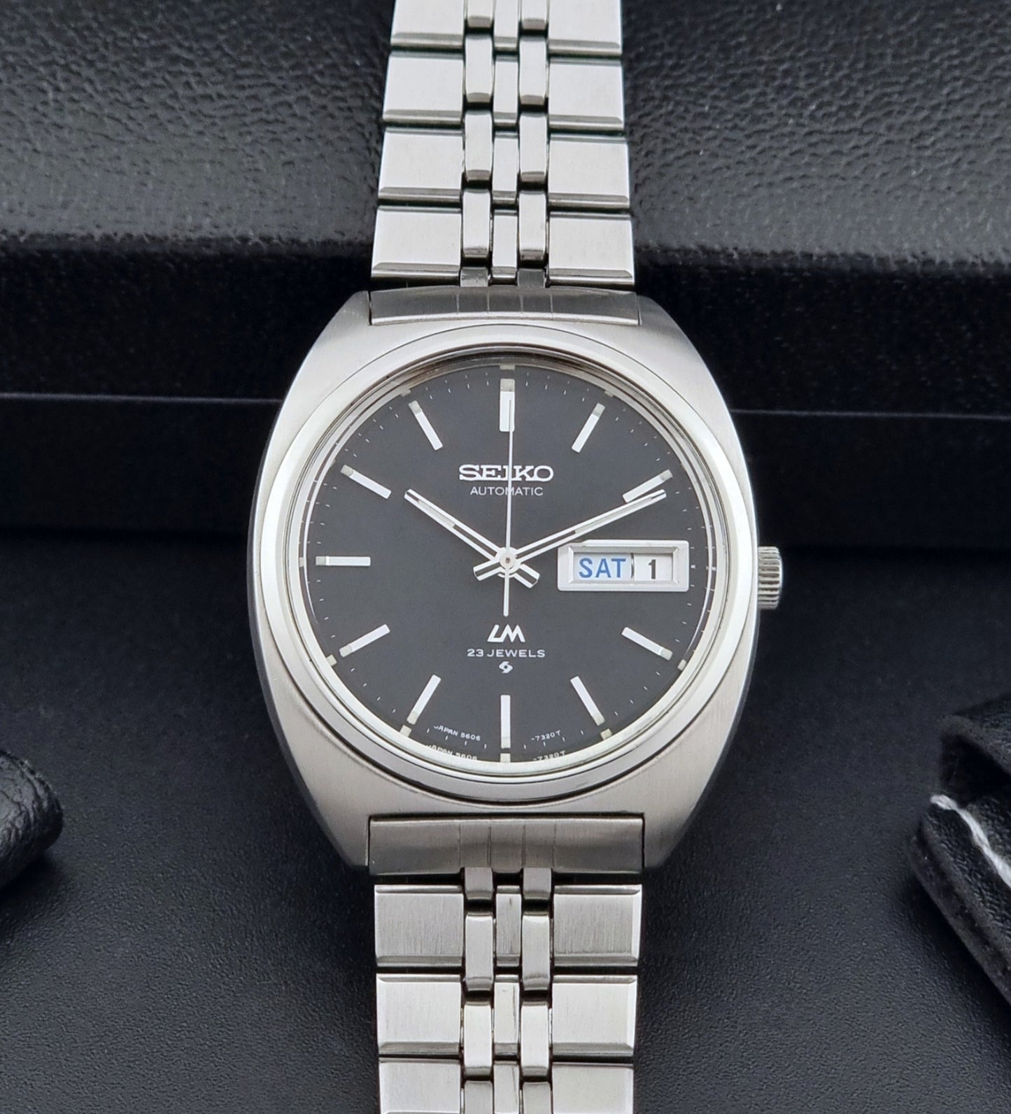 Seiko Wristwatch LordMatic 5606-7140 Vintage watch with a black face on a dark background dial view