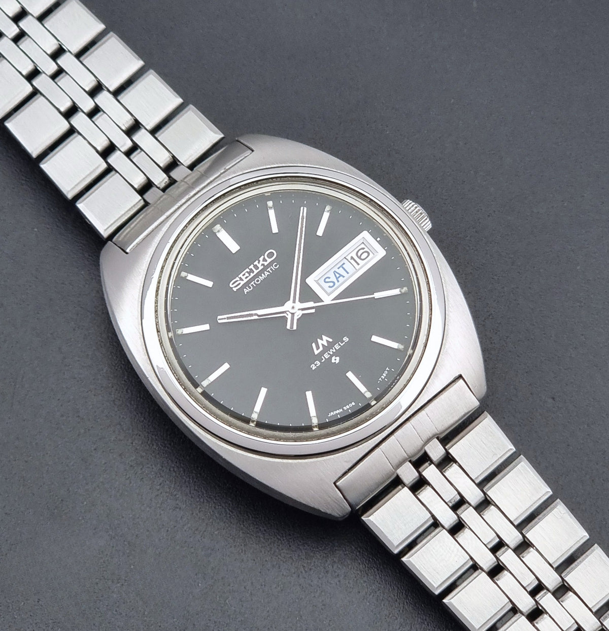 Vintage Seiko Wristwatch LordMatic 5606-7140 with  stainless steel bracelet on a dark background close dial view