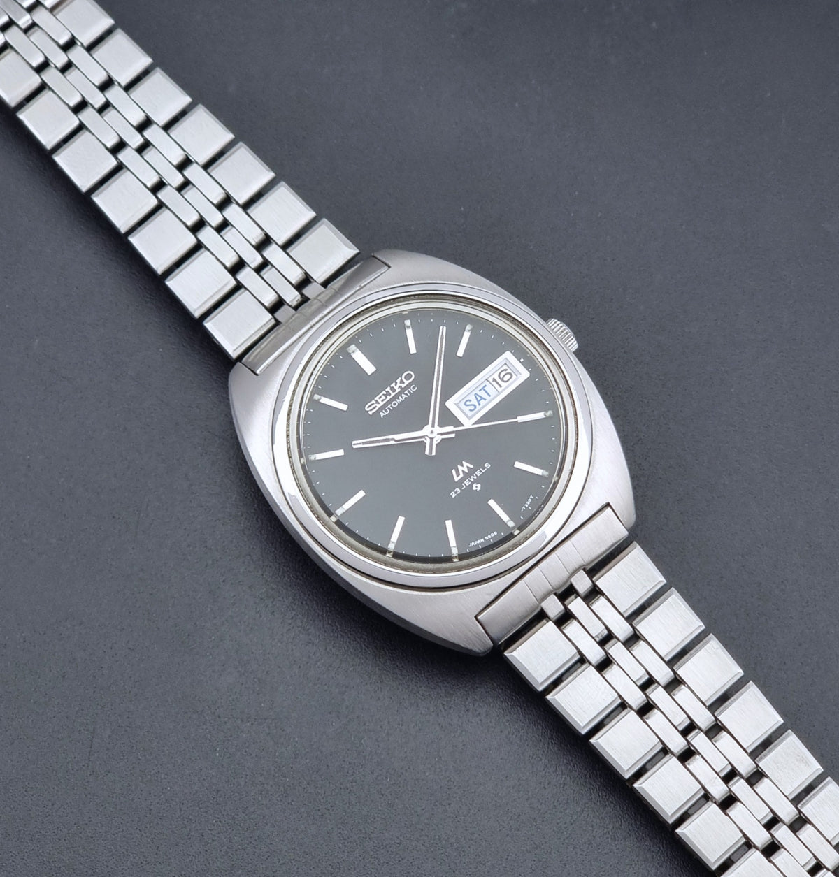 Vintage Seiko Wristwatch LordMatic 5606-7140 with  stainless steel bracelet on a dark background dial