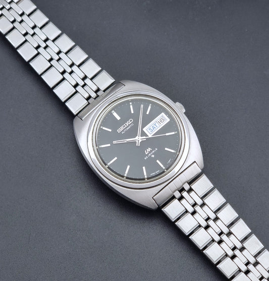 Vintage Seiko Wristwatch LordMatic 5606-7140 with  stainless steel bracelet on a dark background dial