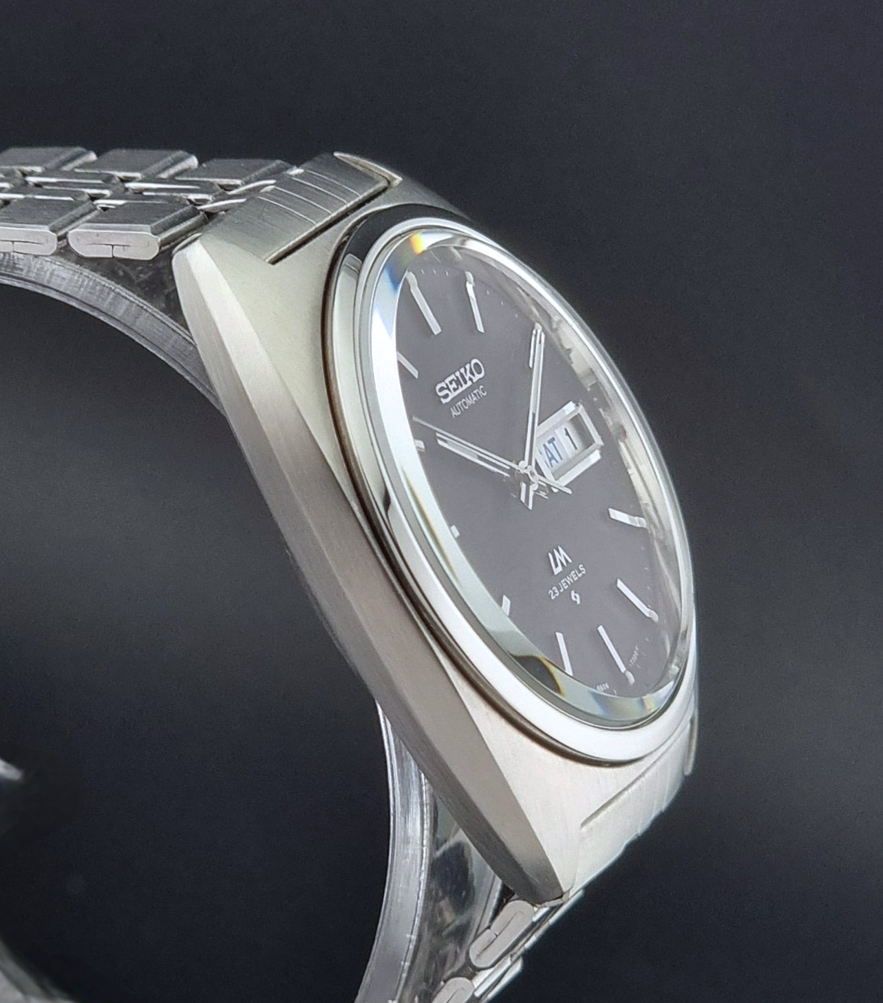 Seiko Wristwatch LordMatic 5606-7140 Vintage watch with a black face on a dark background side profile view