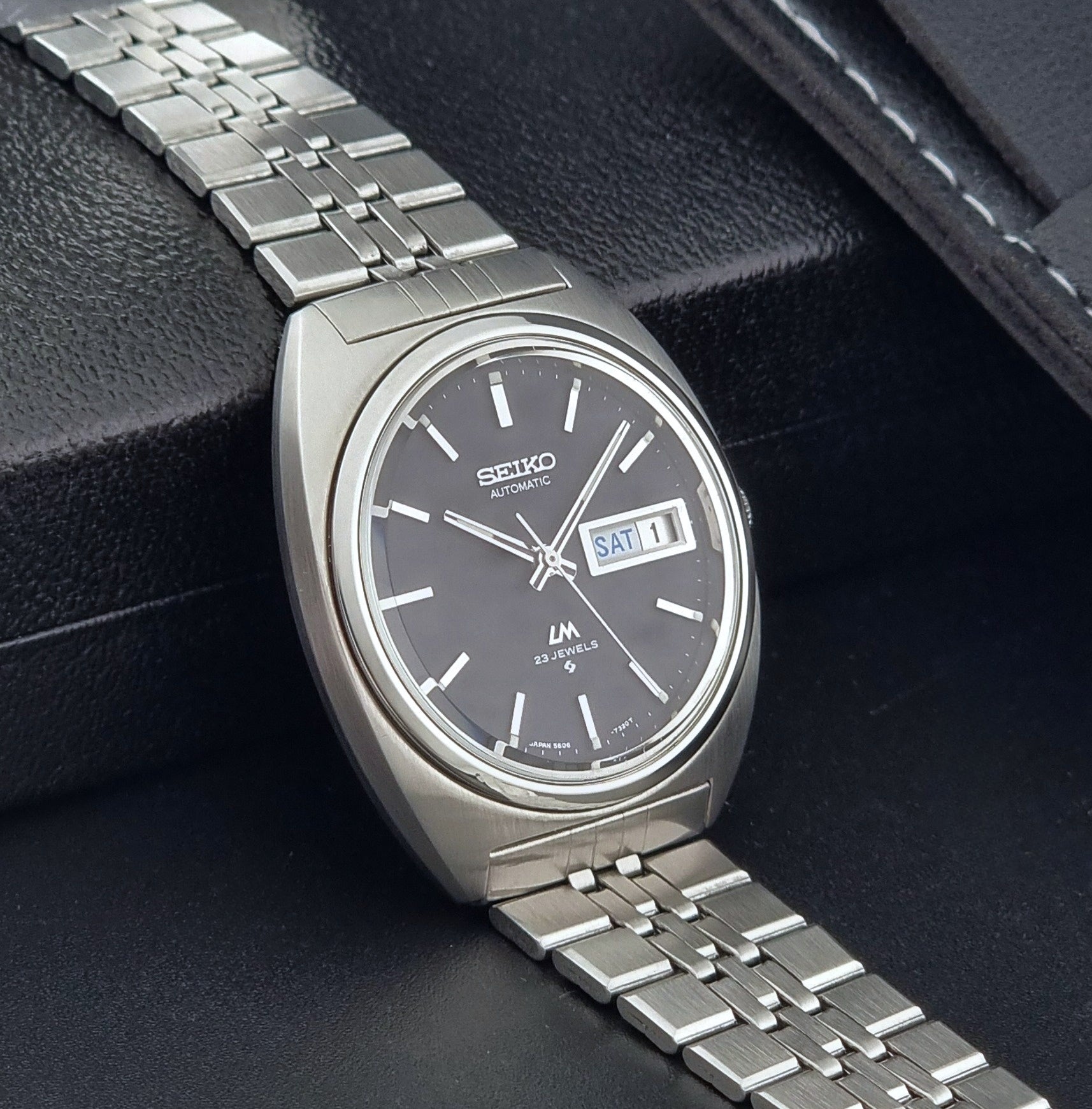Seiko Wristwatch LordMatic 5606-7140 Vintage watch with a black face on a dark background side view