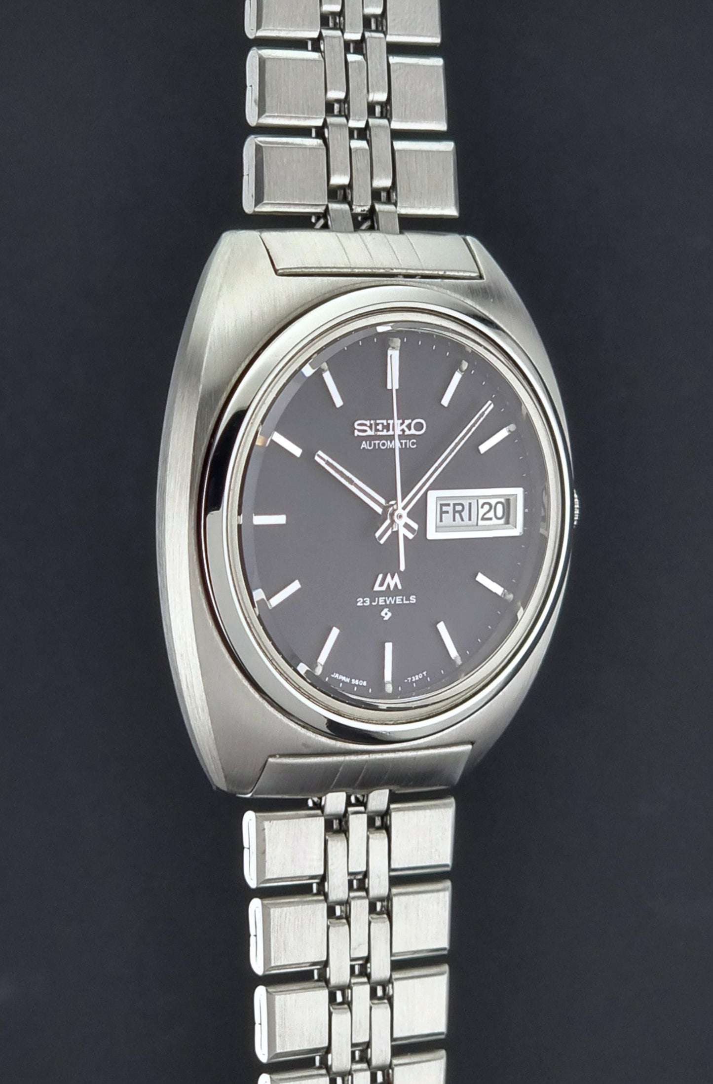 Vintage Seiko Lordmatic 5606-7140 watch with a dark face on a black background