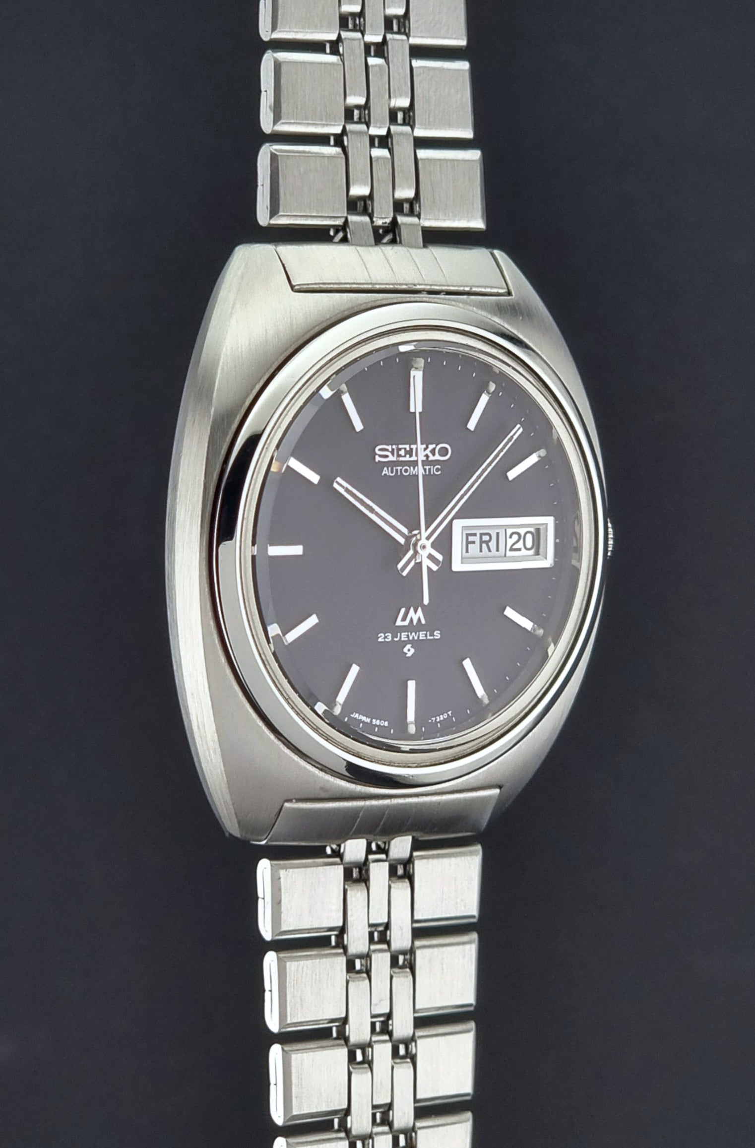 Vintage Seiko Lordmatic 5606-7140 watch with a dark face on a black background