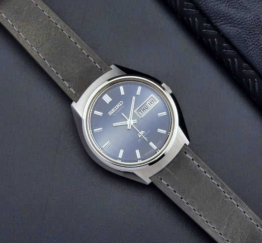 Vintage Seiko 5606-7240 watch with gray strap on a dark background