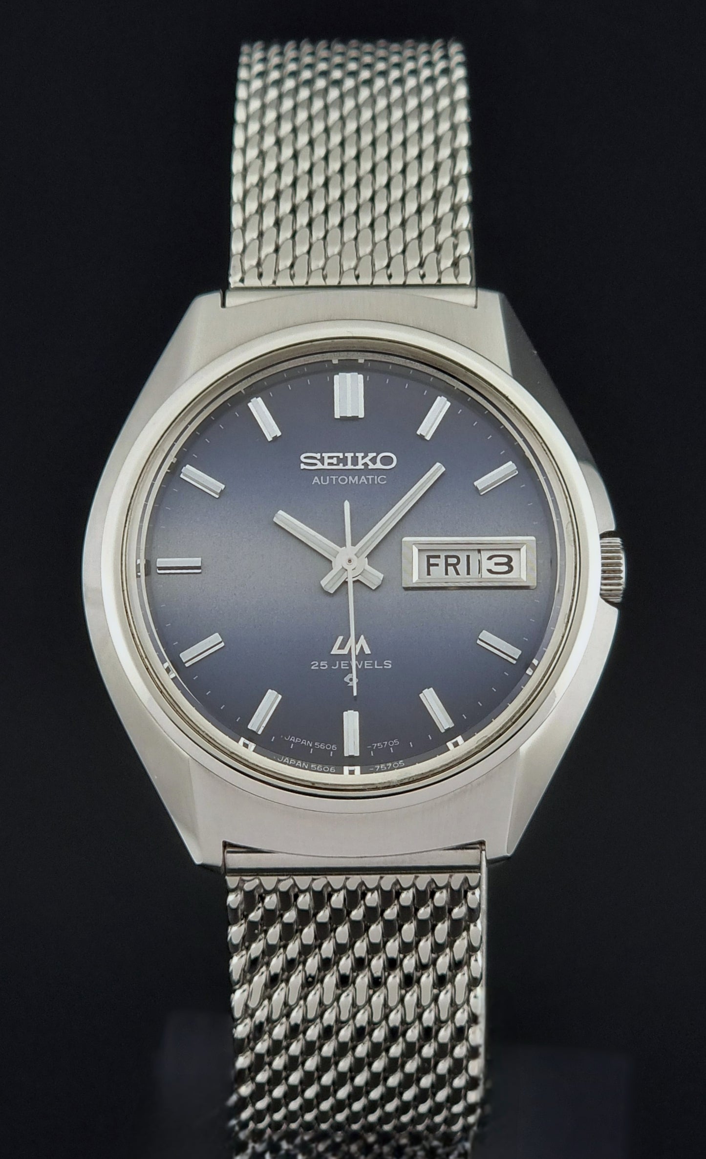 Silver Seiko watch with blue dial on a black background