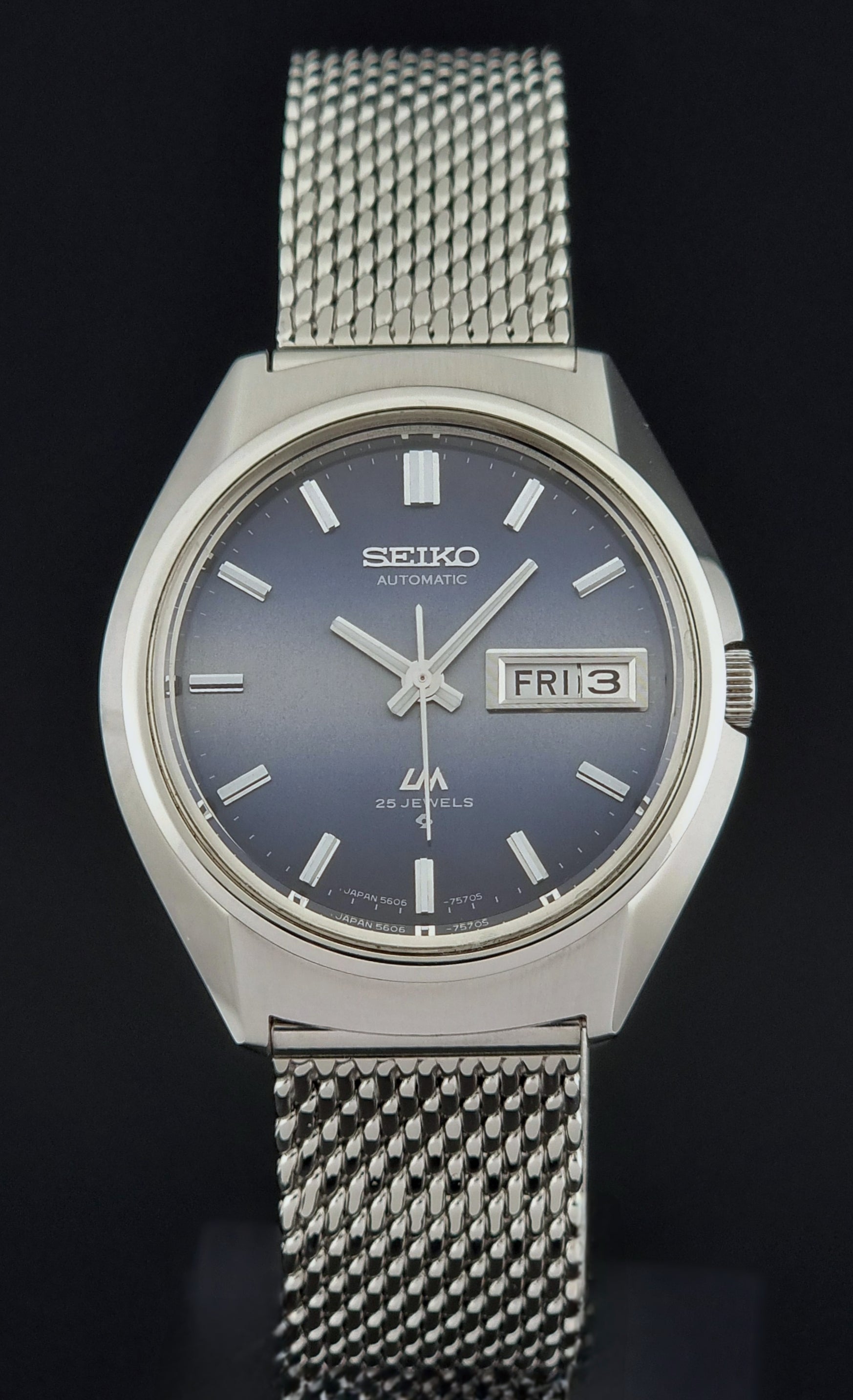 Silver Seiko watch with blue dial on a black background