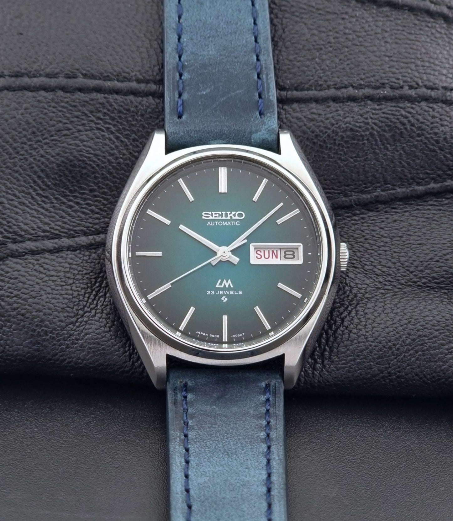 Vintage Seiko watch LordMatic 5606-8050 with blue leather strap on a dark gray background front