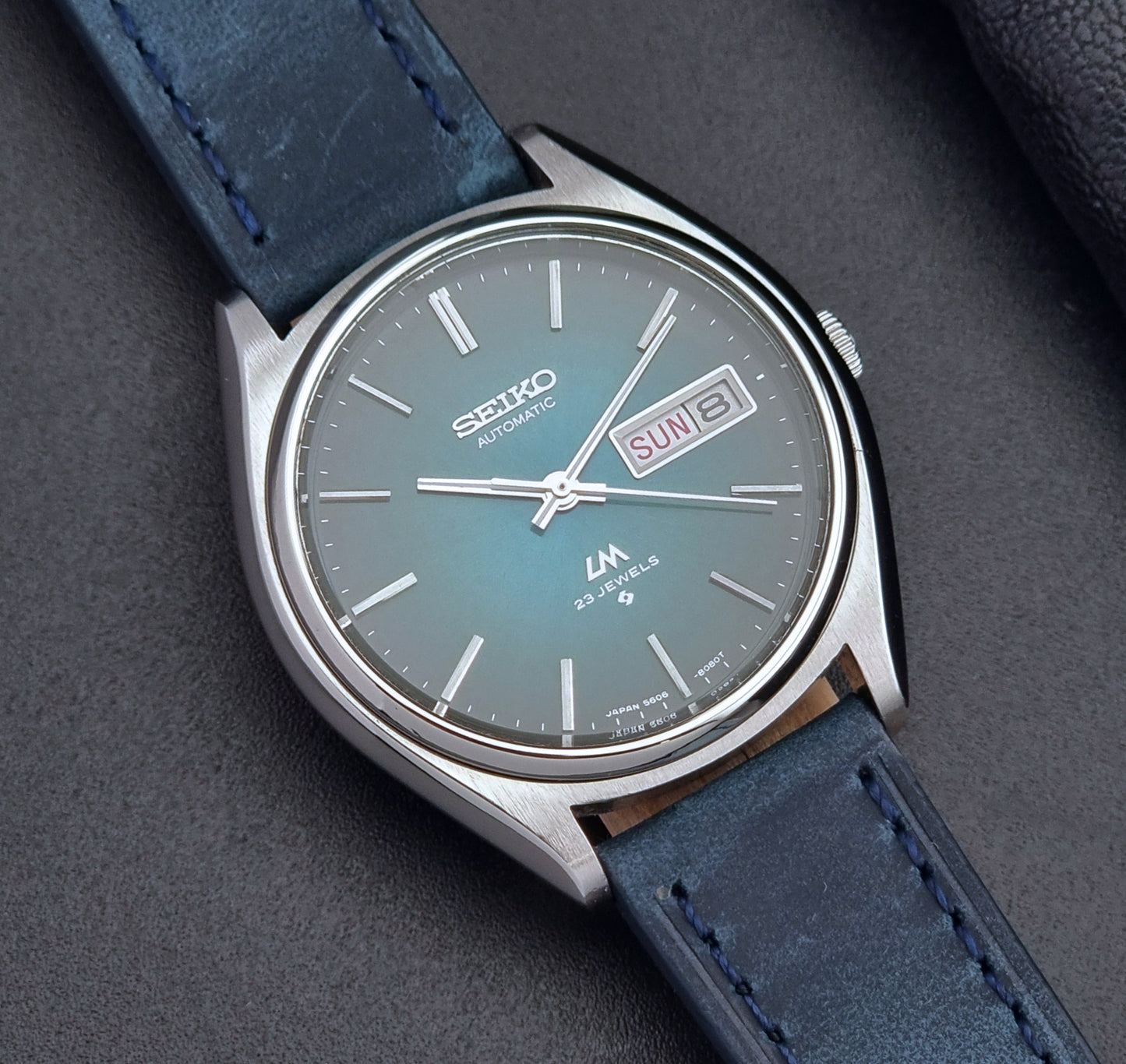 Vintage Seiko watch LordMatic 5606-8050 with blue leather strap on a dark gray background close up