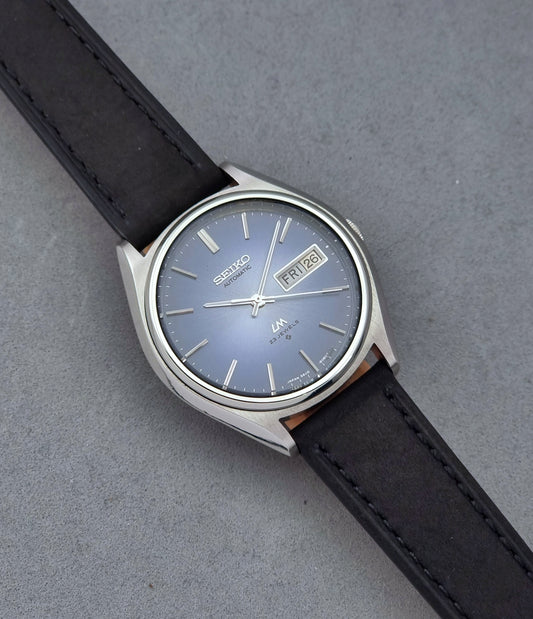 Vintage Seiko Wristwatch LordMatic 5606-8050 with blue gradient dial on a dark surface front