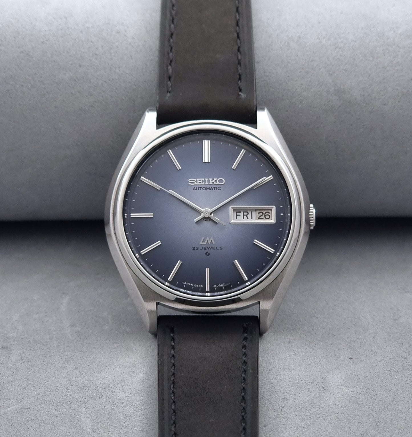 Vintage Seiko Wristwatch LordMatic 5606-8050 with blue gradient dial on a dark surface front view