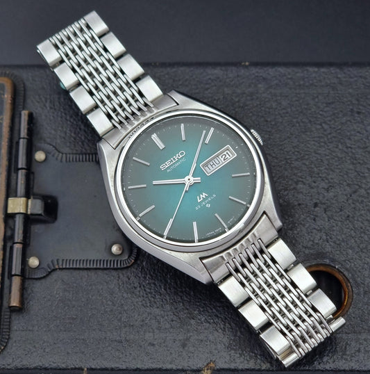 Vintage Seiko watch LordMatic 5606-8050 with a green dial on a dark surface front