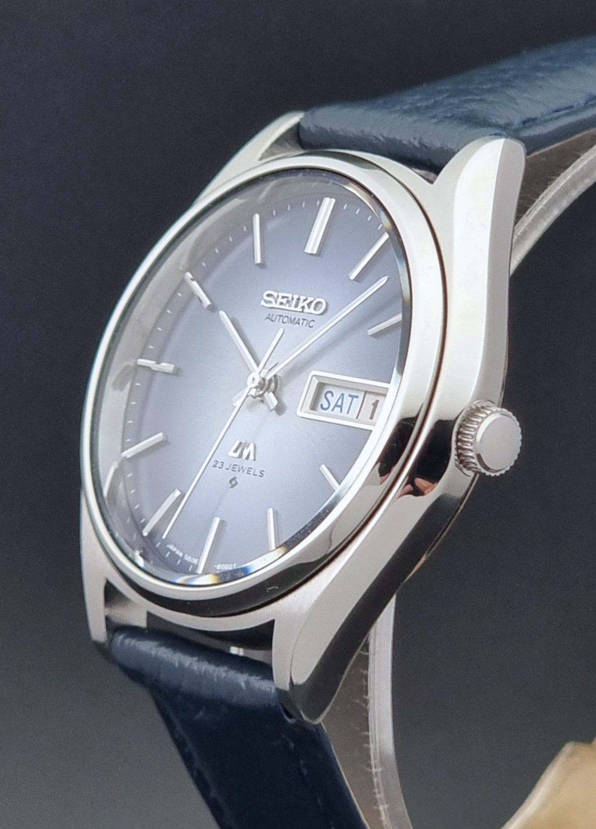 Vintage Seiko Wristwatch LordMatic 5606-8051 with blue strap with blue strap on a dark background crown side profile