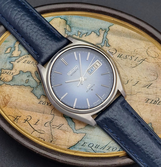 Vintage Seiko Wristwatch LordMatic 5606-8051 with blue strap on an old world map