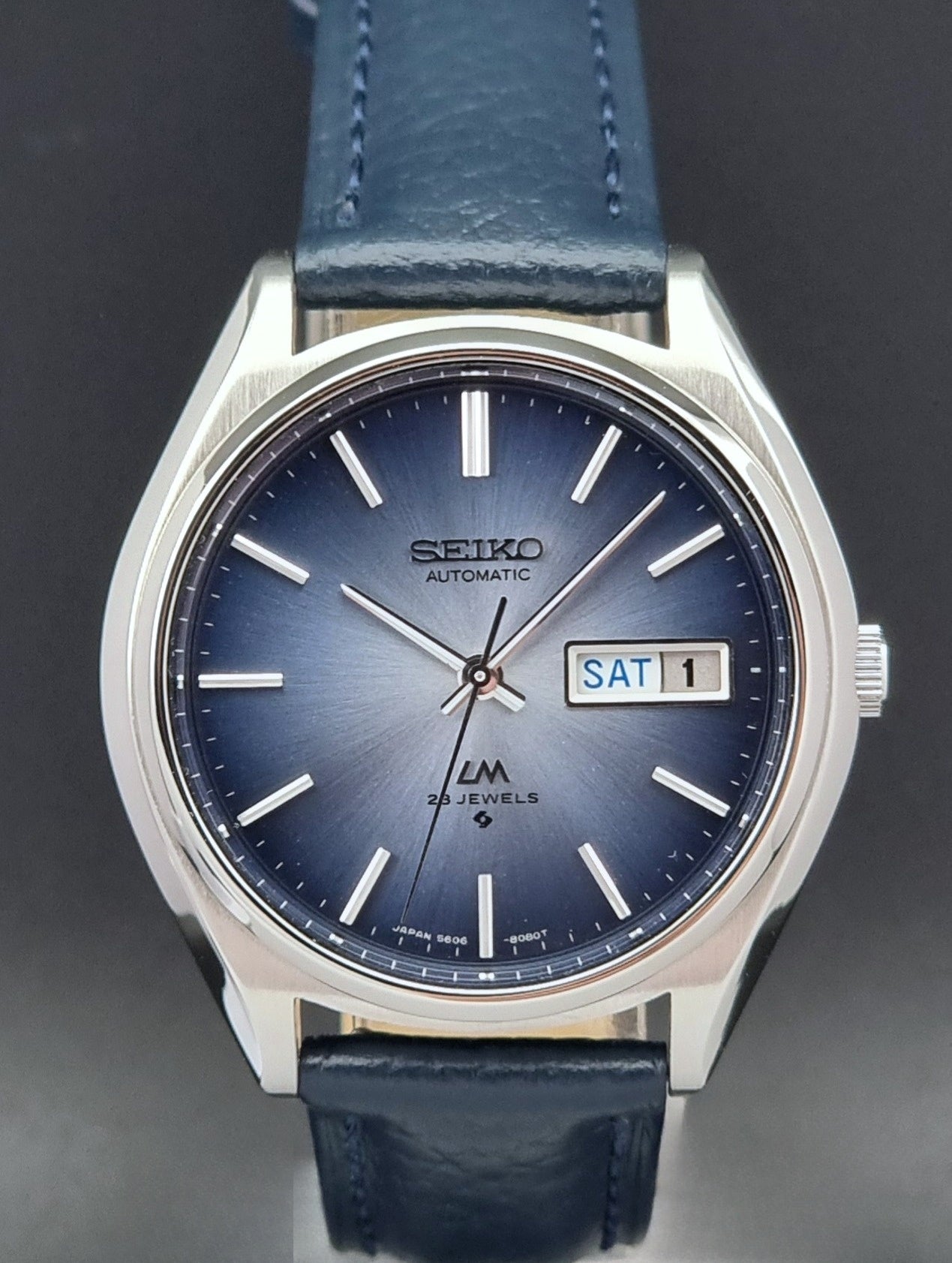 Vintage Seiko Wristwatch LordMatic 5606-8051 with blue strap with blue strap on a dark background blue dial close up