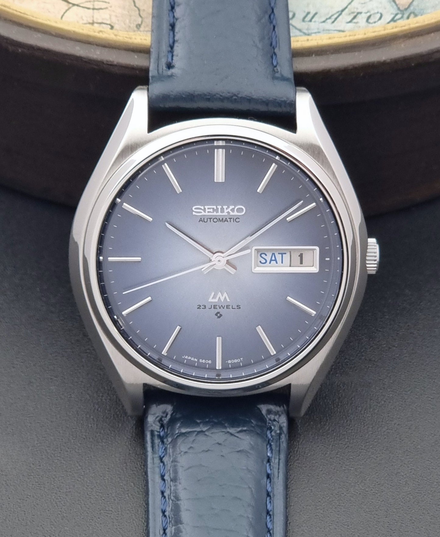 Vintage Seiko Wristwatch LordMatic 5606-8051 with blue strap with blue leather strap on a dark background front