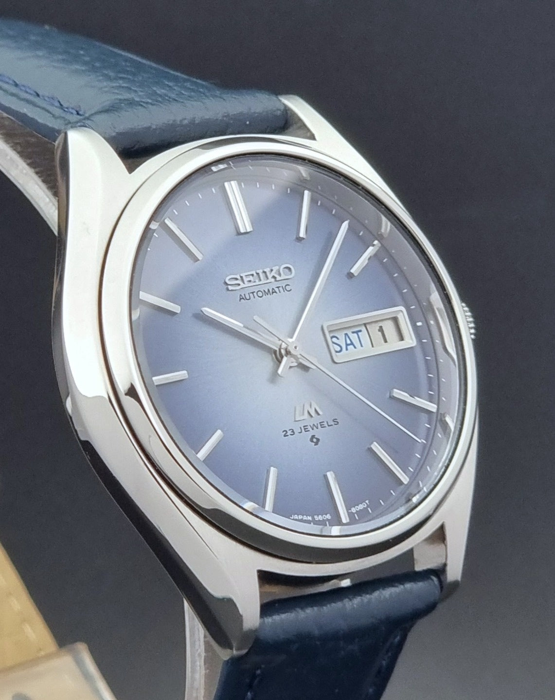 Vintage Seiko Wristwatch LordMatic 5606-8051 with blue strap with blue strap on a dark background profile