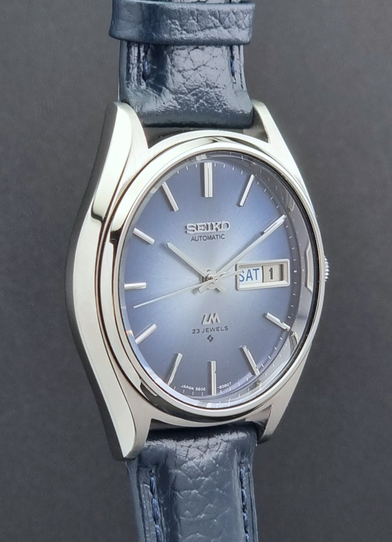 Vintage Seiko Wristwatch LordMatic 5606-8051 with blue strap with blue strap on a dark background blue dial profile