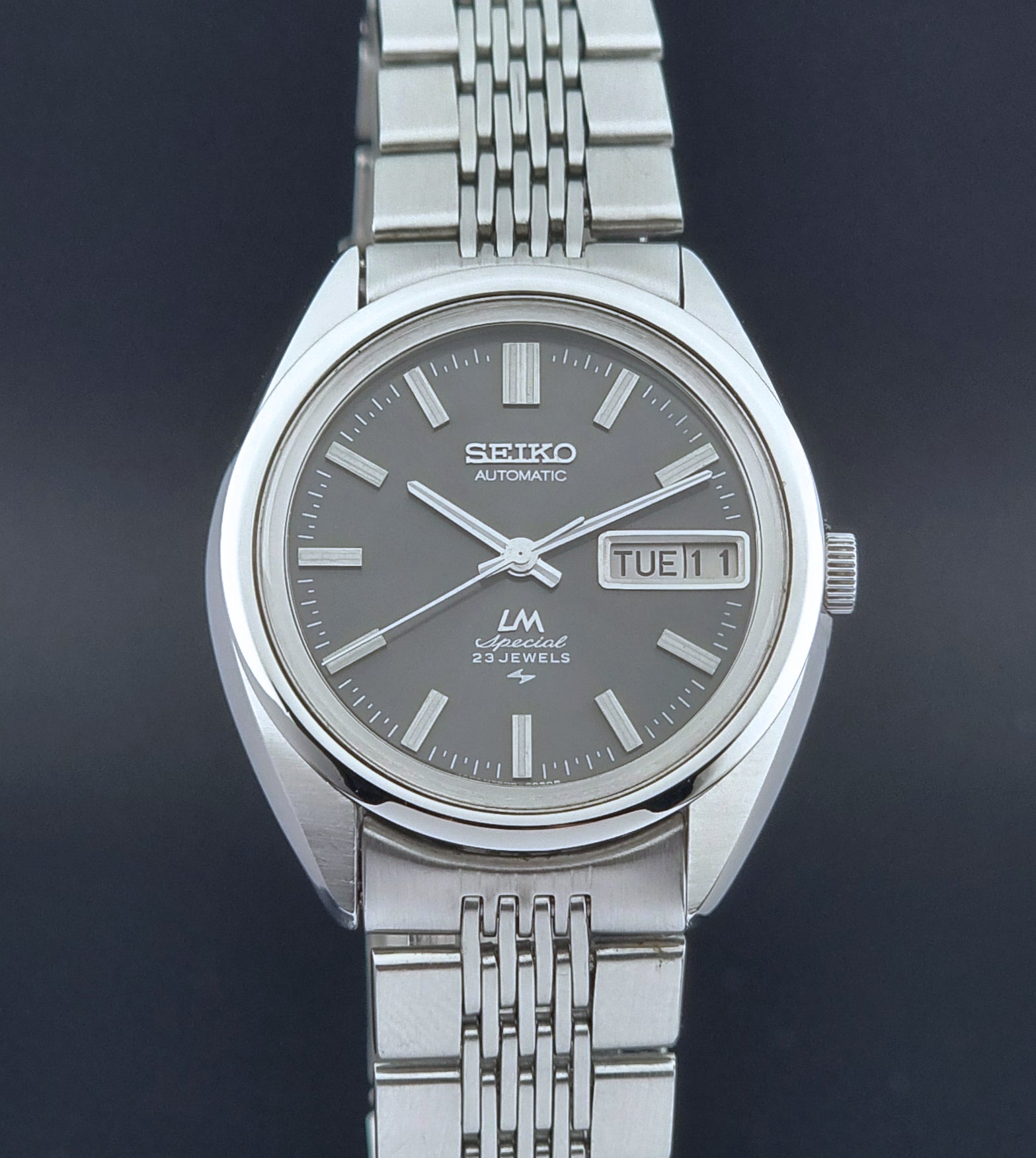 Vintage Seiko LordMatic Special 5206-6021 wristwatch with a dark gray face on a black background close up front view