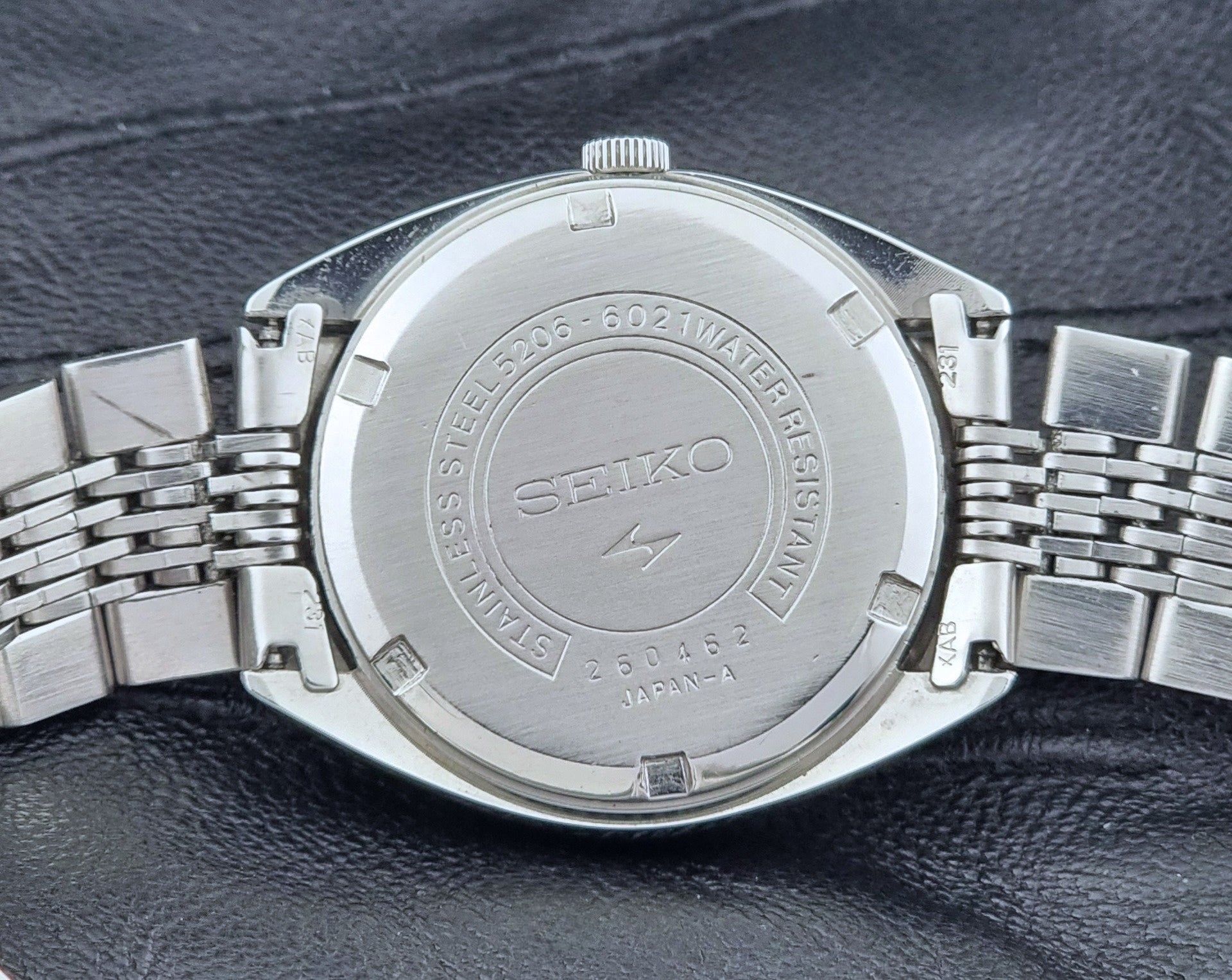 Vintage Seiko LordMatic Special 5206-6021 wristwatch with a dark gray face on a black background case back view