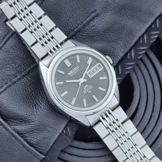 Vintage Seiko LordMatic Special 5206-6021 wristwatch with a dark gray face on a black background front