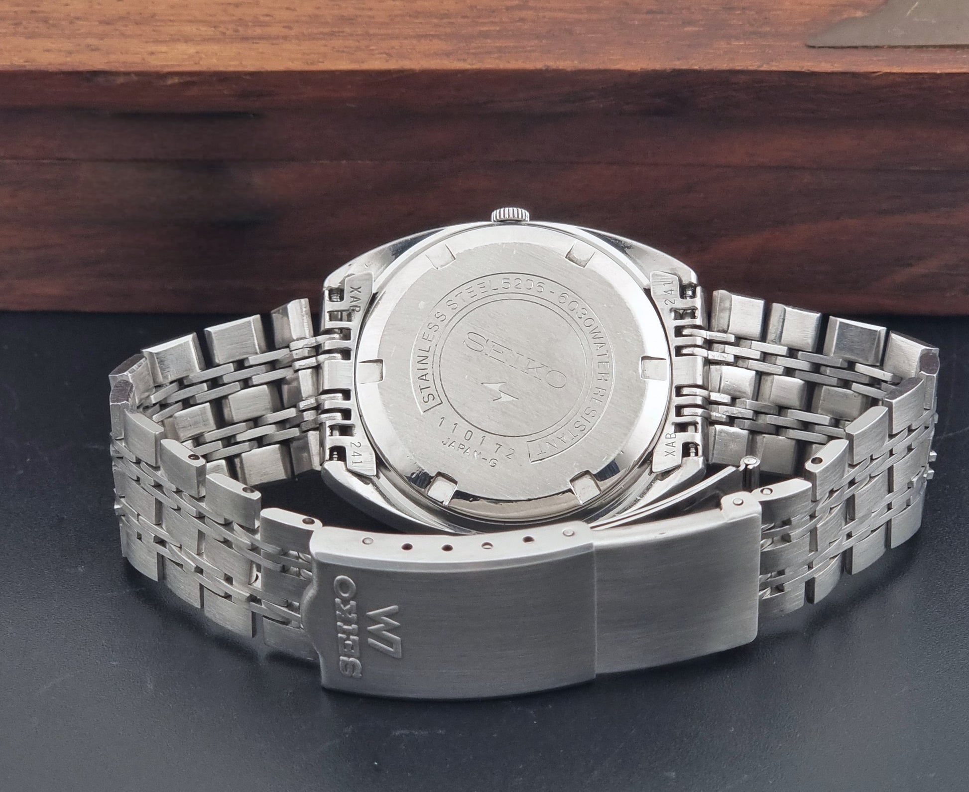 Vintage Seiko watch LordMatic Special 5206-6030 with a stainless steel bracelet on a dark background clasp view