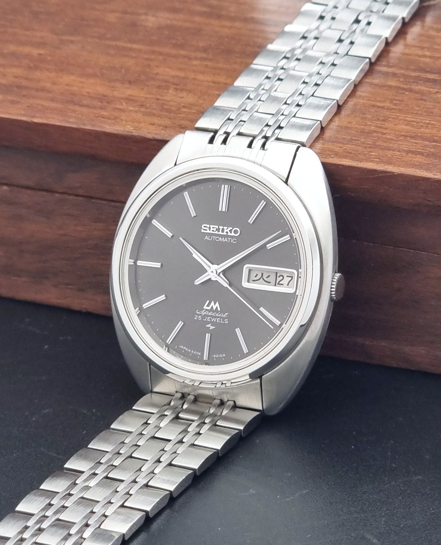 Vintage Seiko watch LordMatic Special 5206-6030 with a stainless steel bracelet on a dark background crown view